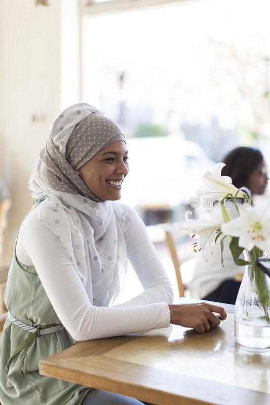 美丽的穆斯林女人坐在开普敦的桌子旁