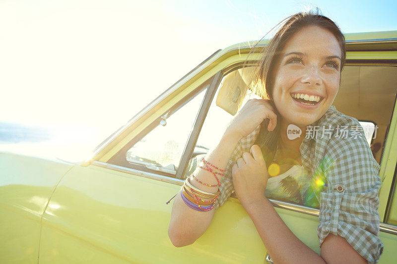 微笑的年轻女子探出车窗