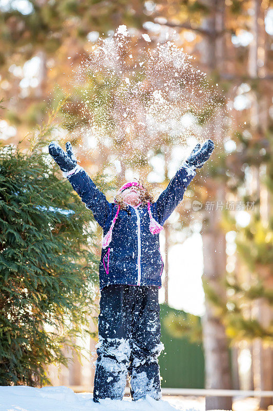 年轻女孩向空中抛雪