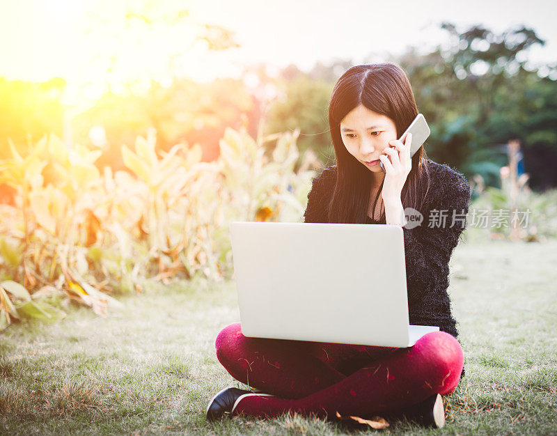 在户外使用手提电脑和手机的女人