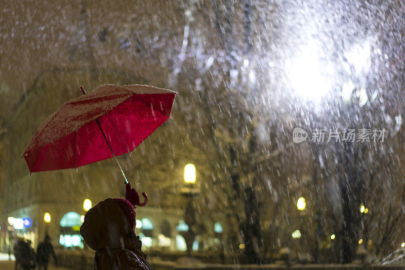 斯洛文尼亚Presern广场上飘落的伞和雪。