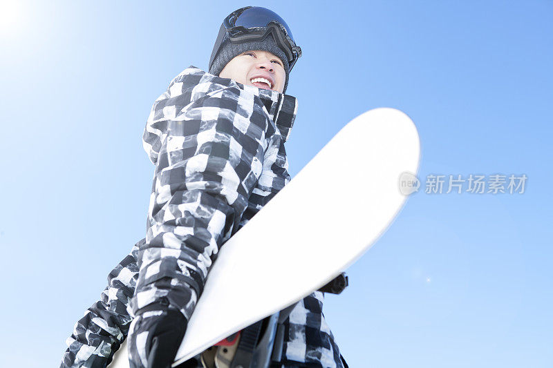 快乐的男性滑雪板对蓝色的天空