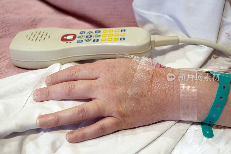 女医院病人的手，静脉滴注，电视遥控器