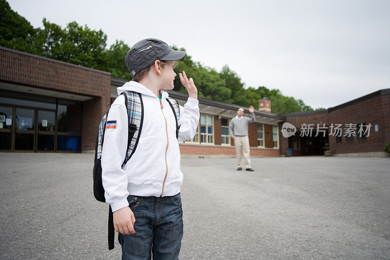 孩子在学校前向老师挥手告别