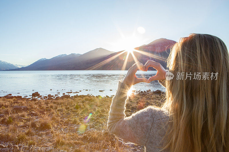 湖边的女人做了心形的指架