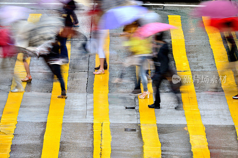 在雨中穿过香港街道的行人的动作模糊了
