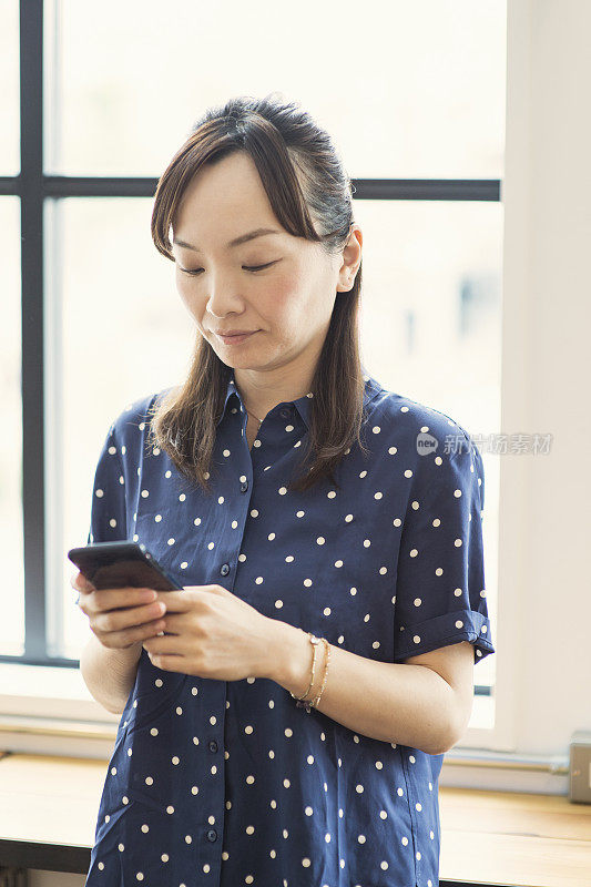 一个在客房用智能手机的女人