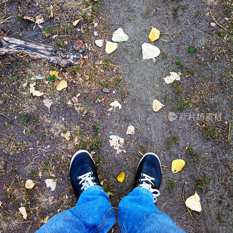 脚踩在干树叶上。