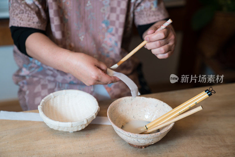 传统的日本手工艺妇女画一个手工的纸碗