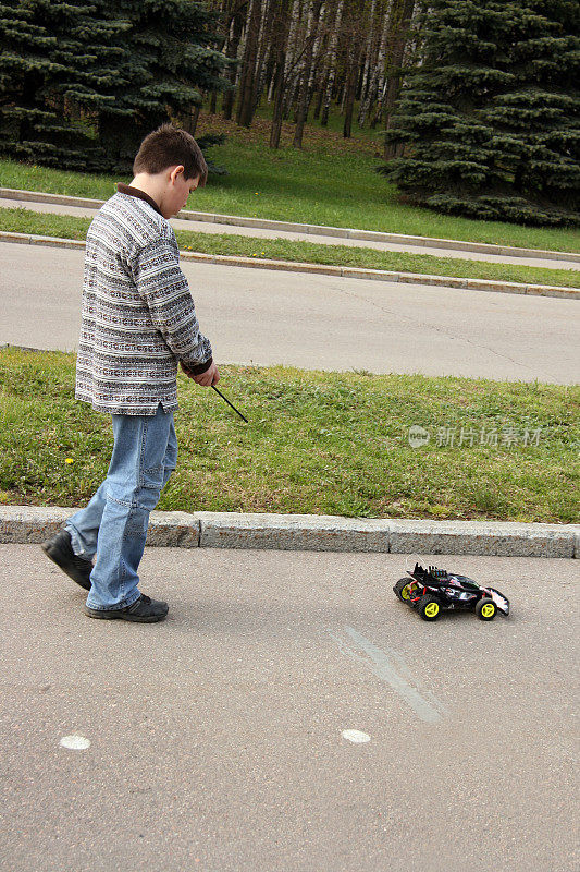 一个男生在公园里开着玩具车