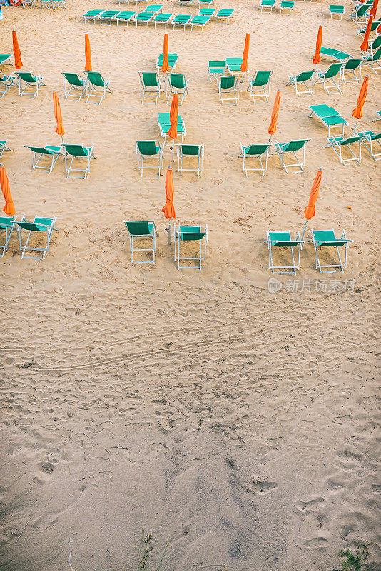 九月海滩上的遮阳伞和日光浴床