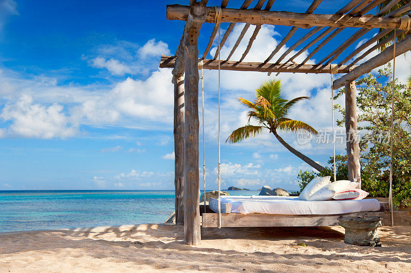 加勒比海热带海滩上的天篷床