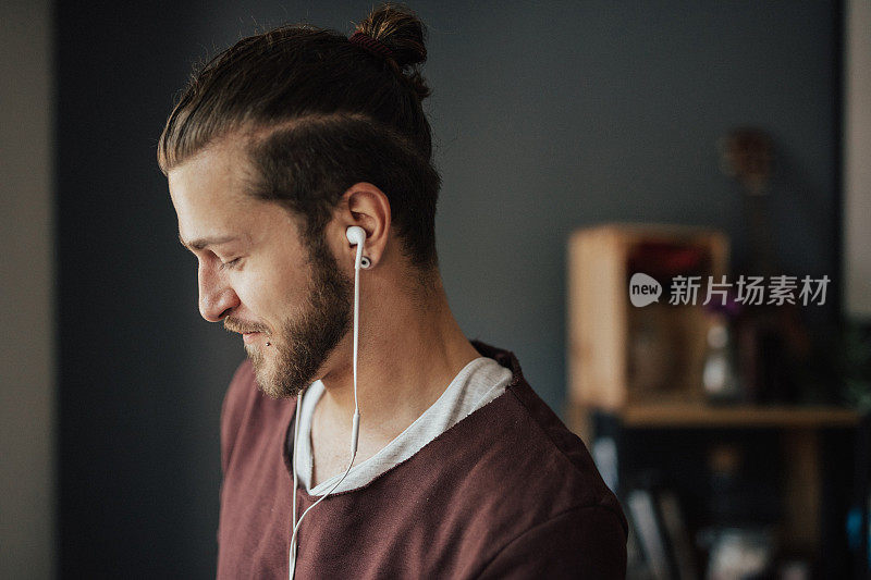 微笑的男人戴着耳机听播客