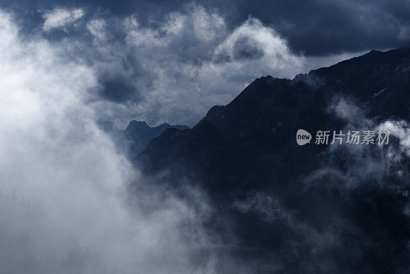 潮湿的山脉在巴伐利亚阿尔卑斯和多云的天空剪影