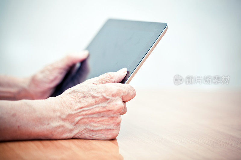 一个老人在用平板电脑