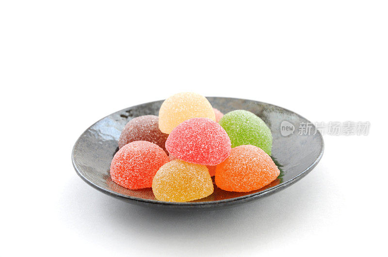 彩色糖果果冻豆孤立在盘子上的白色背景