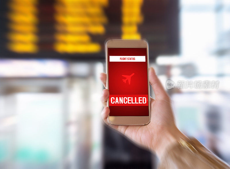 航班取消了。智能手机应用程序向游客宣布坏消息。飞机罢工或问题。在机场候机楼拿着手机的女人。时间表和时间表在模糊的背景。