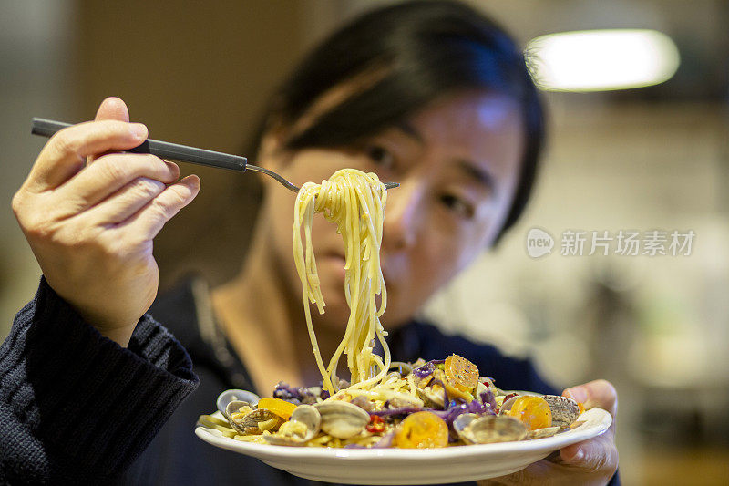 女孩品尝海鲜面食