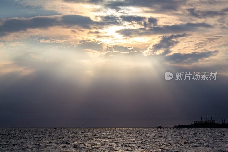 背光的海和天空与阳光照射下来的影响。