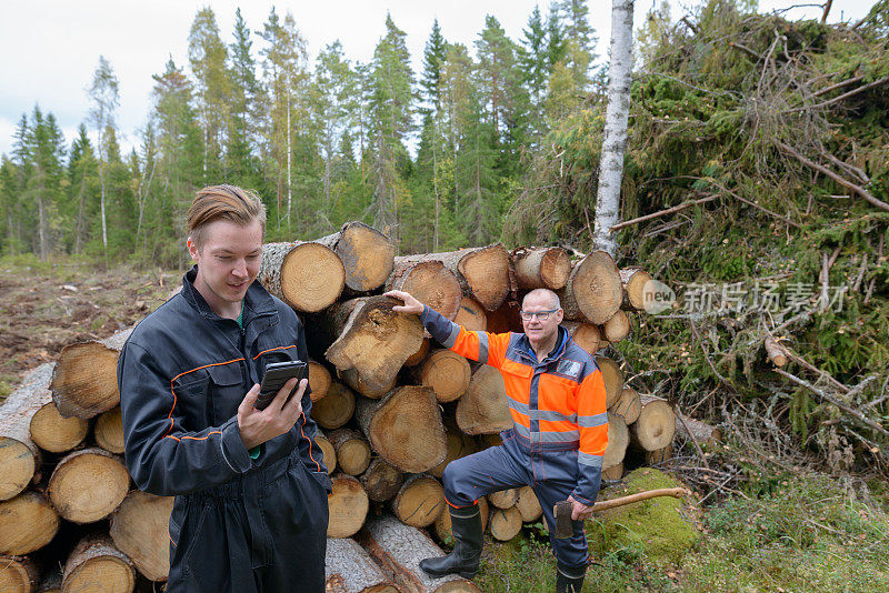 一个成熟的男人和一个年轻的男人一起在森林里工作