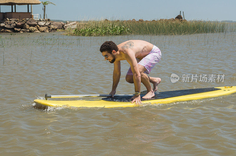 年轻人在湖上练习立桨