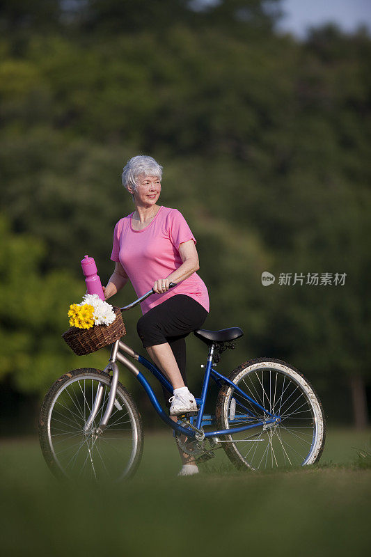 在公园里骑自行车的老妇人