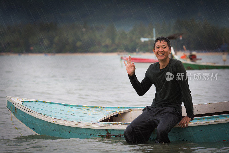 人坐在小船上，在大雨中欢笑。