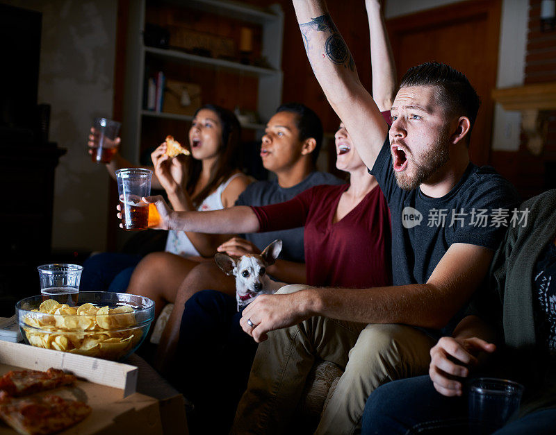 一群兴奋的朋友在看电视比赛时欢呼