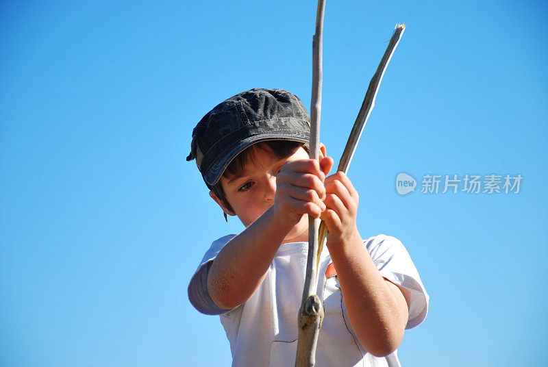 家庭生活方式的海滩;玩木棍的孩子