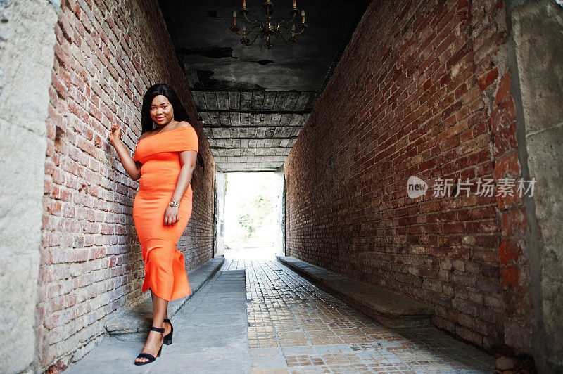 非裔美国女模特xxl穿橙色的衣服。