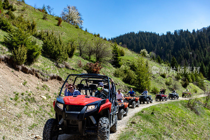 一个旅游团乘坐全地形车和utv在山上旅行