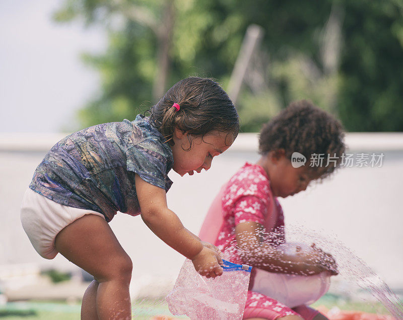 小女孩在后院玩水管。
