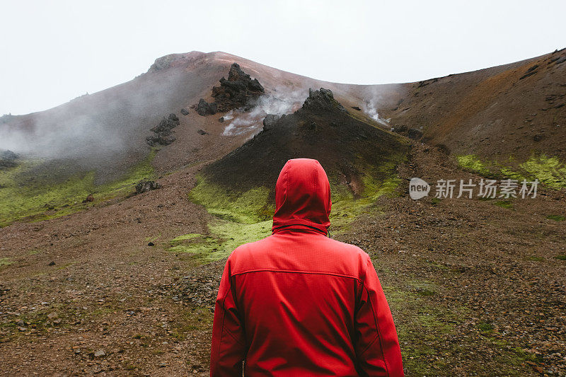 红色的男人在冰岛高地的地热地区徒步旅行