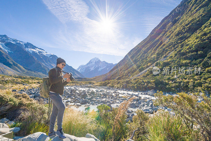 年轻的旅行者在库克法默斯山的目的地在新西兰拍照