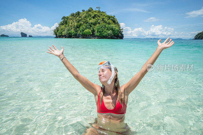 快乐的年轻女人在海滩度假探索热带岛屿