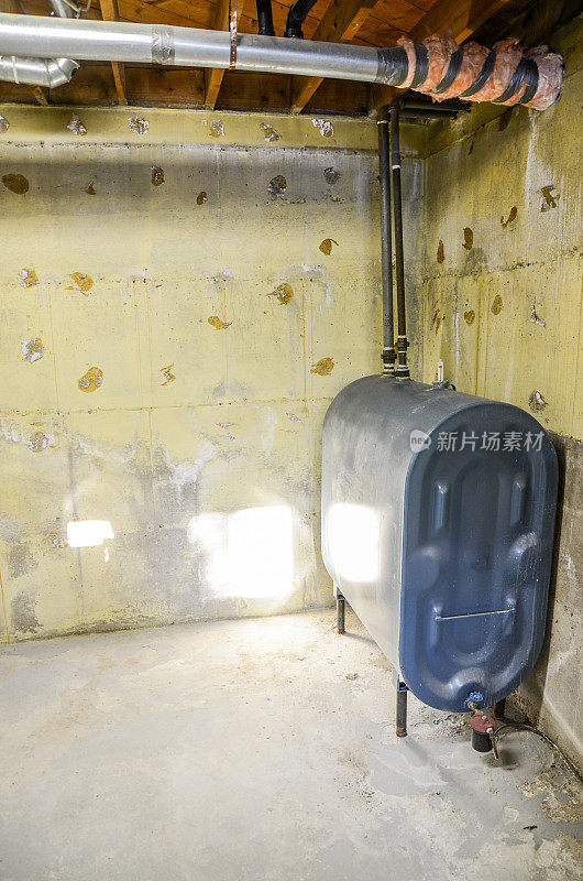 住宅裸露的混凝土地下室墙体，带有加热油箱
