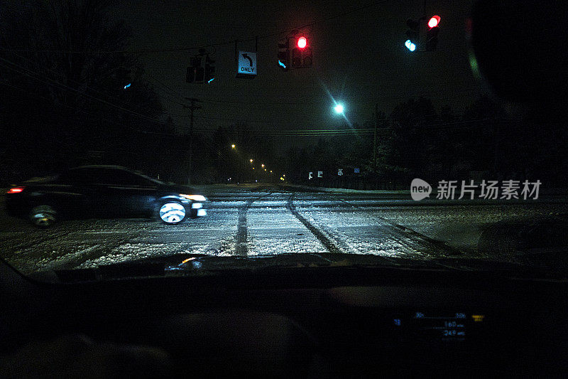 红灯在冬季暴风雪路交叉口的交通信号