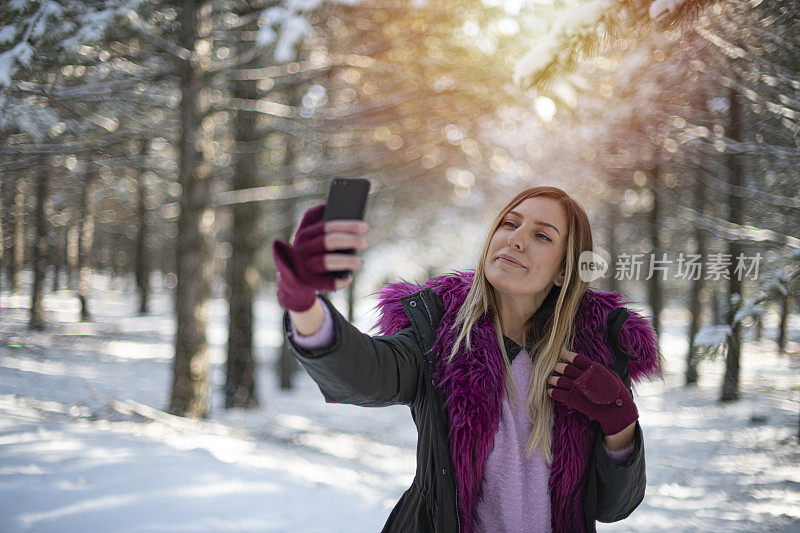 可爱的女人在雪域森林里自拍