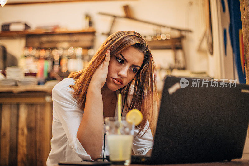 严肃的年轻女子在用笔记本电脑