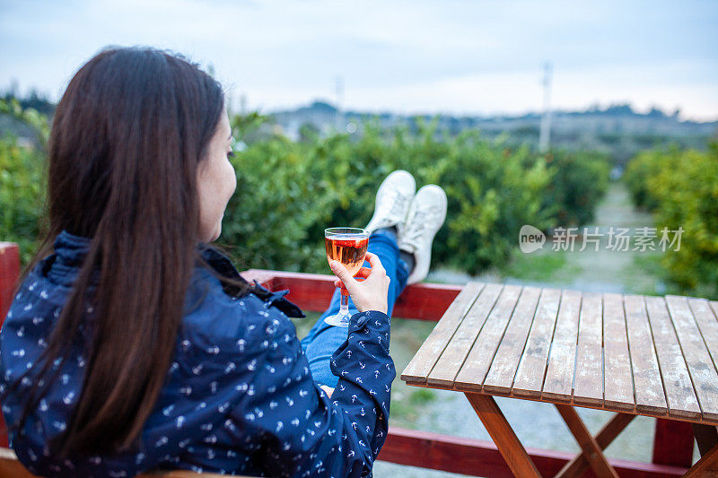 年轻女子在阳台上放松与葡萄酒库存照片