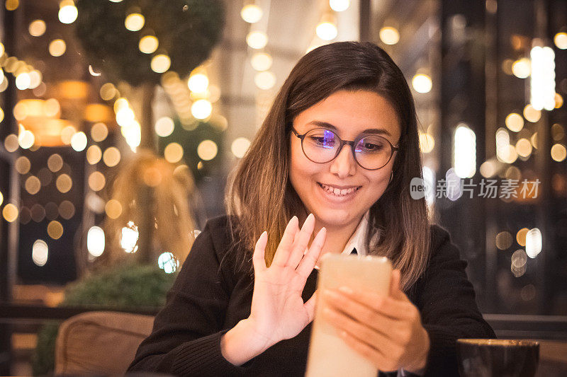 一名年轻女子在咖啡馆使用智能手机