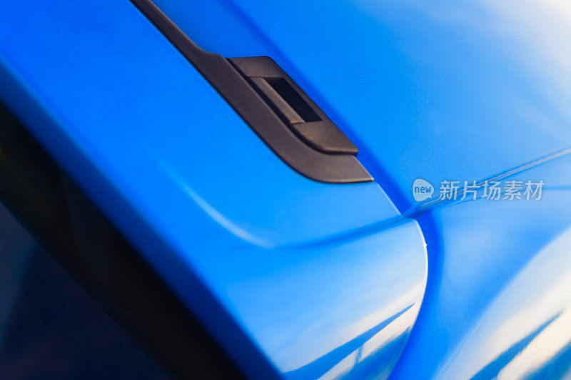 一个现代紧凑型掀背车空气动力扰流板的细节在亮蓝色