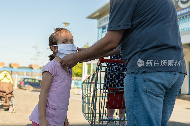 单身父亲给女儿戴上防护口罩去超市