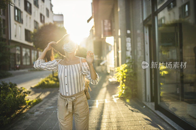 为预防冠状病毒和防雾霾，年轻妇女戴着口罩上街的肖像