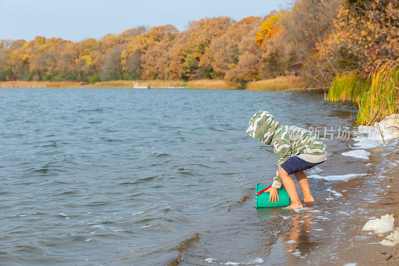 秋天的早晨，男孩在湖中玩耍