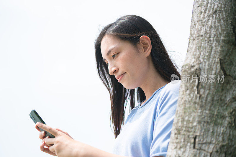 在户外使用智能手机的亚洲年轻女性