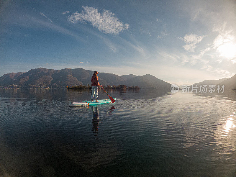 年轻女子在湖上用桨板划水