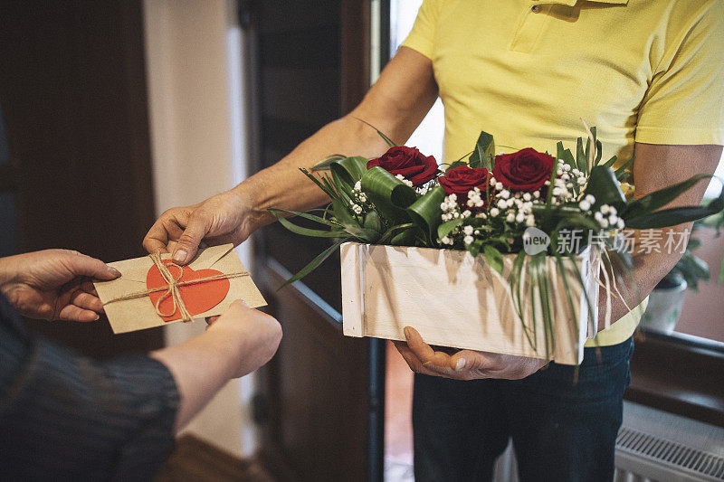 女人从送货员那里收到花束。
