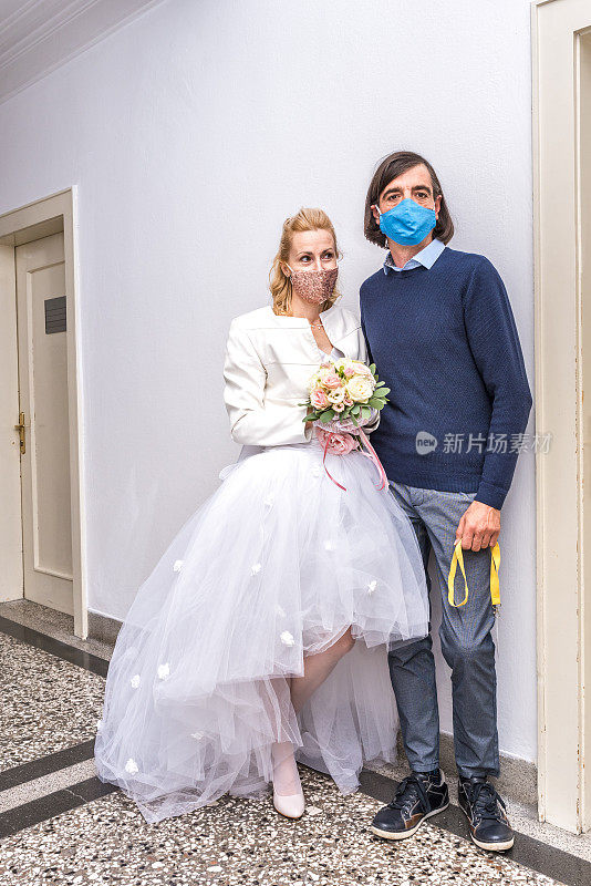 新冠肺炎疫情期间，戴着防护口罩的新郎新娘在法院举行婚礼