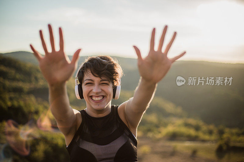 在大自然中锻炼后休息的健康女性。一个快乐，美丽的女人享受乐趣和笑声训练后的自然。